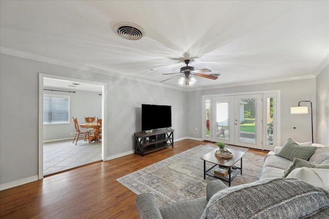 980 N 23rd St, Beaumont, TX 77706 - living area featuring wood finished floors, healthy amount of natural light, ornamental molding, ceiling fan, and baseboards
