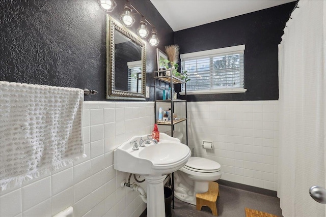 980 N 23rd St, Beaumont, TX 77706 - bathroom with tile walls, a wainscoted wall, and toilet