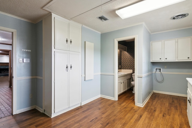 interior space featuring washer hookup, crown molding, and dark hardwood / wood-style flooring