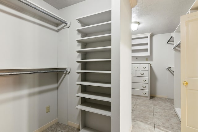 walk in closet with light tile patterned flooring