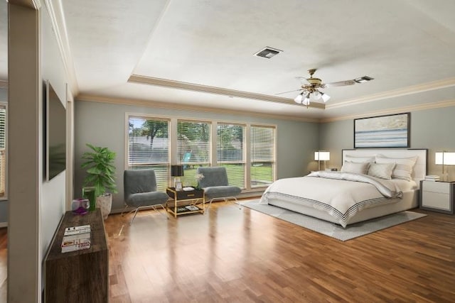 bedroom featuring hardwood / wood-style flooring, ceiling fan, crown molding, and a raised ceiling