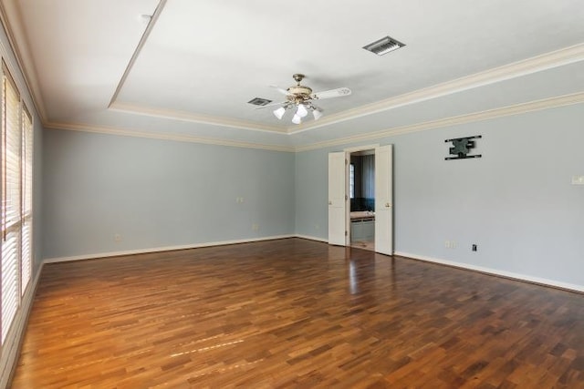 empty room featuring ceiling fan, ornamental molding, a tray ceiling, and dark hardwood / wood-style flooring