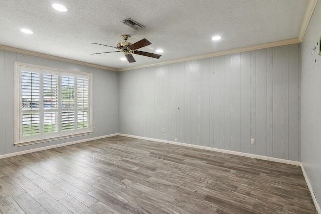 unfurnished room with hardwood / wood-style flooring, ceiling fan, and crown molding