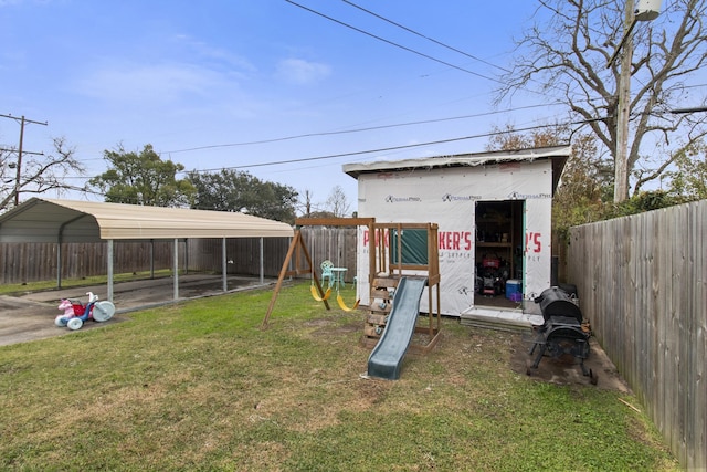 view of outbuilding with a playground, a yard, and a carport