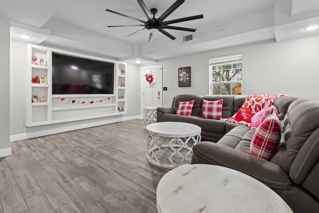 living room with ceiling fan, hardwood / wood-style floors, and built in shelves