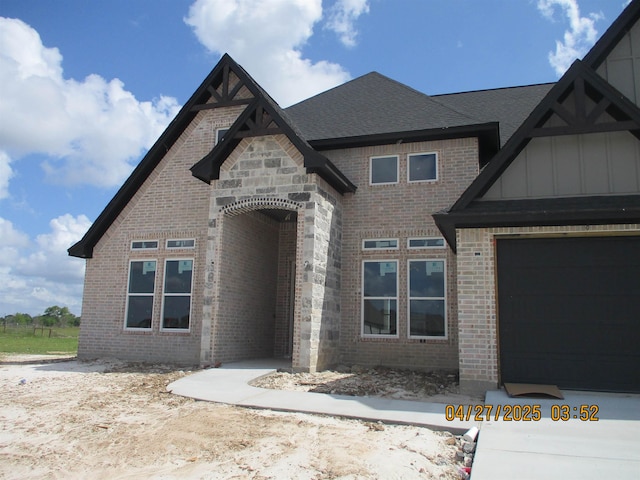 9250 Bellflower St, Beaumont, TX 77713 - view of front of home featuring a shingled roof, board and batten siding, and brick siding
