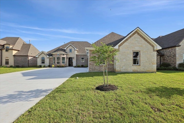 9250 Bellflower St, Beaumont, TX 77713 - french country inspired facade featuring driveway, a front lawn, and stone siding