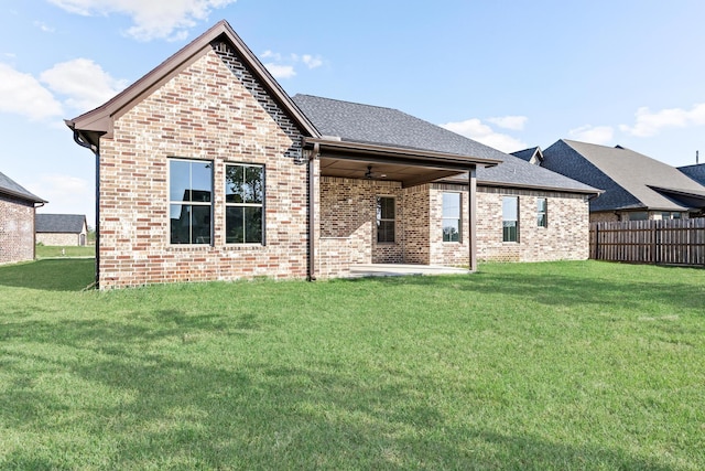 back of house featuring a lawn and ceiling fan