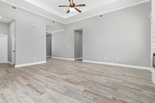 unfurnished room with light wood-type flooring, a raised ceiling, ceiling fan, and ornamental molding