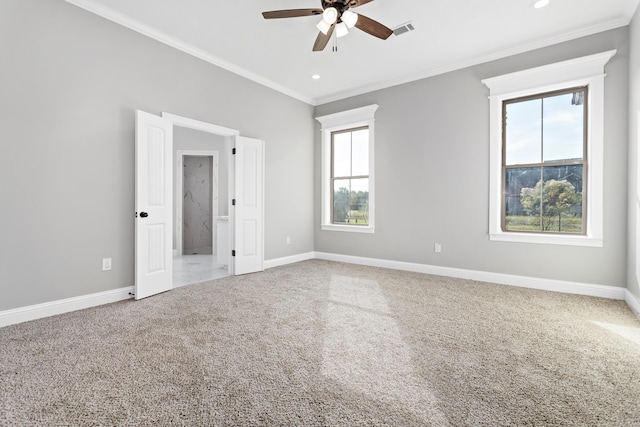 carpeted empty room with plenty of natural light, ceiling fan, and ornamental molding