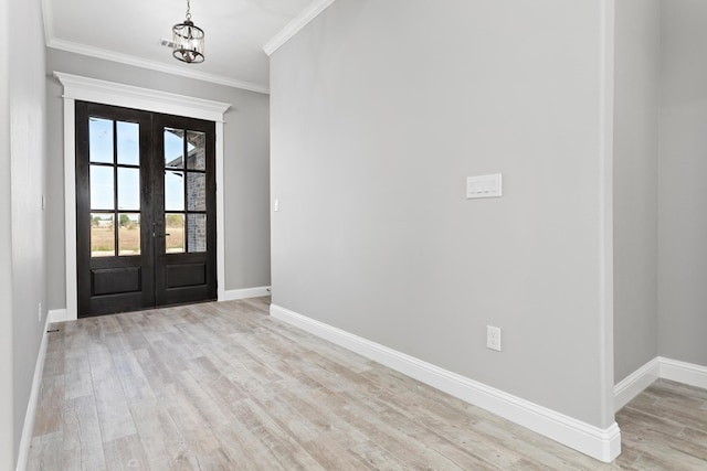 entryway with french doors, light hardwood / wood-style floors, crown molding, and a notable chandelier