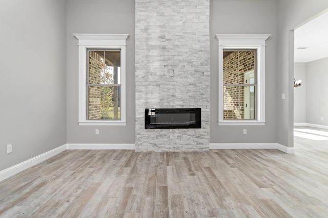 unfurnished living room featuring a fireplace and light hardwood / wood-style floors