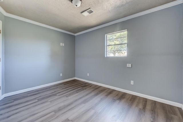 empty room featuring hardwood / wood-style floors, crown molding, and a textured ceiling