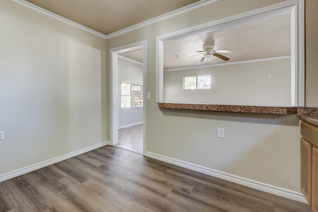 empty room with hardwood / wood-style flooring, ceiling fan, and ornamental molding