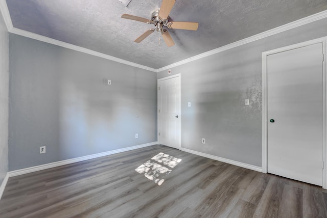 empty room with ornamental molding, a textured ceiling, ceiling fan, and dark wood-type flooring