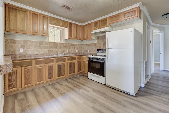 kitchen featuring white appliances, light hardwood / wood-style flooring, ornamental molding, a textured ceiling, and tasteful backsplash