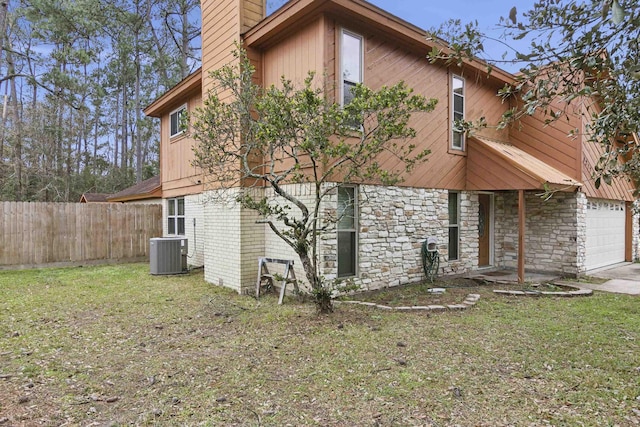 view of property exterior with a garage, a yard, and central AC unit