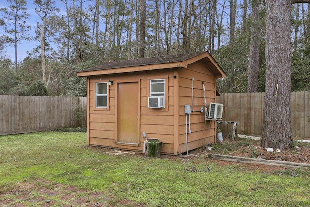 view of outbuilding featuring cooling unit and a lawn