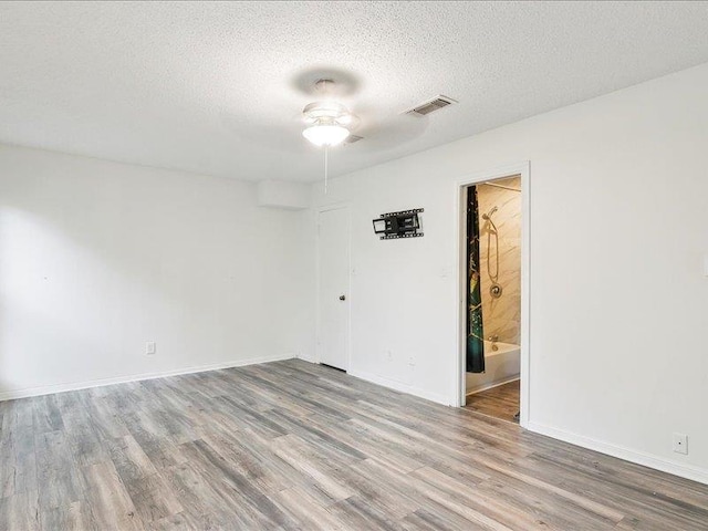 spare room with ceiling fan, hardwood / wood-style floors, and a textured ceiling