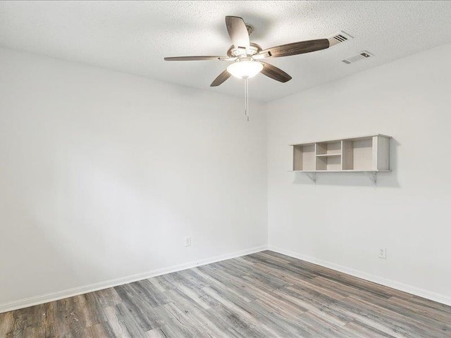 unfurnished room featuring wood-type flooring, ceiling fan, and a textured ceiling