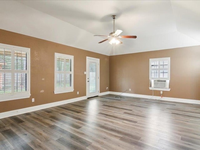 empty room with cooling unit, ceiling fan, vaulted ceiling, and hardwood / wood-style floors