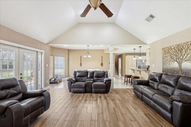 6006 Hazelwood Dr, Orange, TX 77632 - living room featuring french doors, lofted ceiling, ornate columns, light wood-type flooring, and ceiling fan