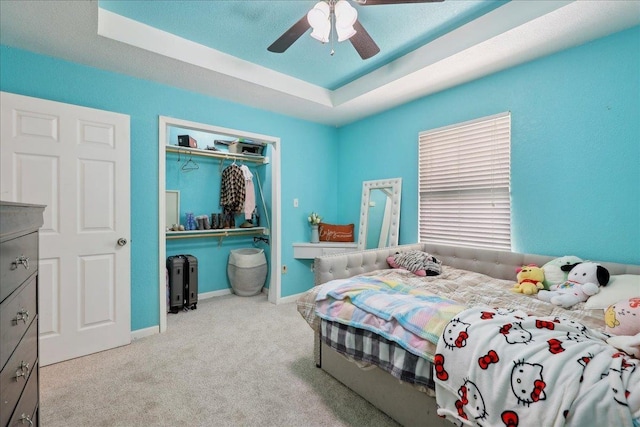 6006 Hazelwood Dr, Orange, TX 77632 - bedroom featuring light carpet, a tray ceiling, a closet, and ceiling fan