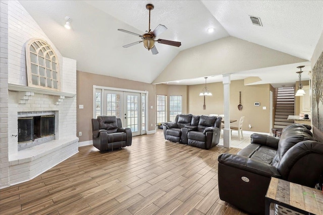 6006 Hazelwood Dr, Orange, TX 77632 - living room featuring ceiling fan, high vaulted ceiling, a textured ceiling, a brick fireplace, and light wood-type flooring
