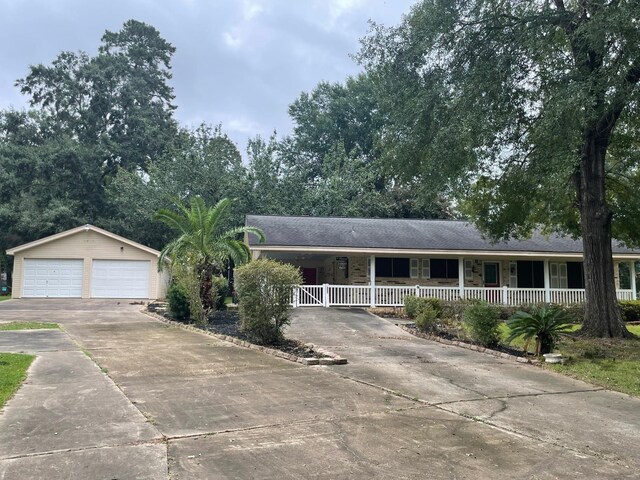 single story home with a porch, a garage, and an outdoor structure