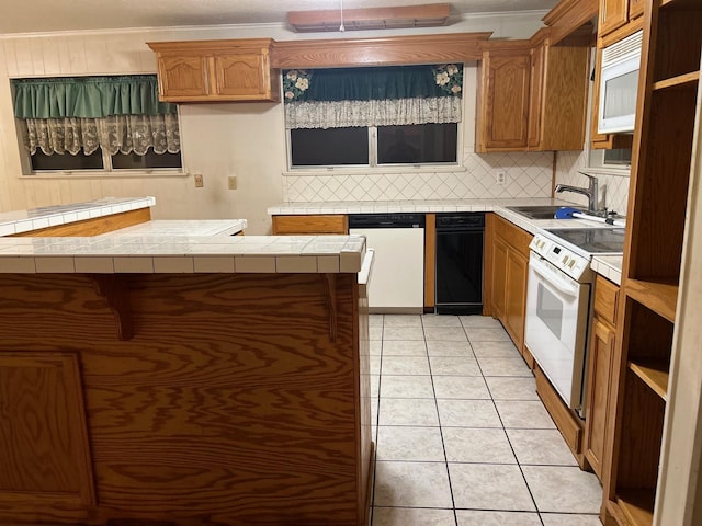 kitchen with sink, tile countertops, kitchen peninsula, white appliances, and light tile patterned flooring