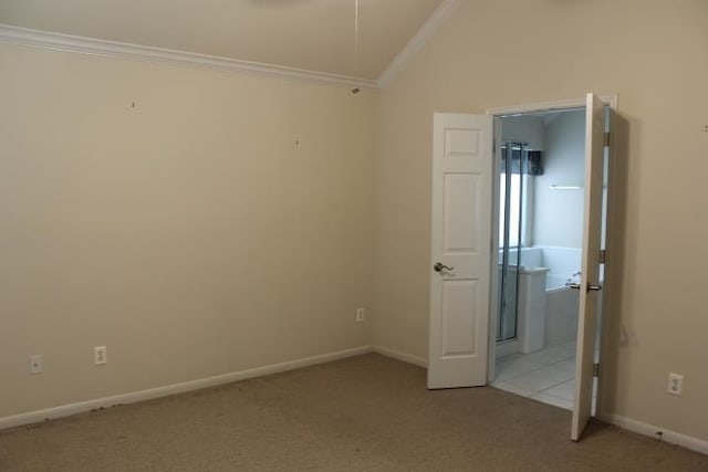 unfurnished bedroom featuring attic access, carpet flooring, crown molding, and vaulted ceiling