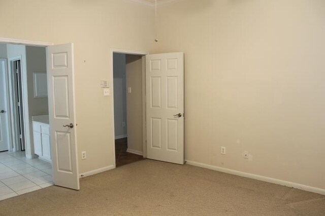 unfurnished bedroom featuring baseboards and light colored carpet