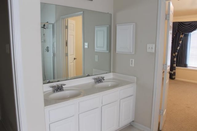 full bathroom featuring double vanity, a stall shower, baseboards, and a sink