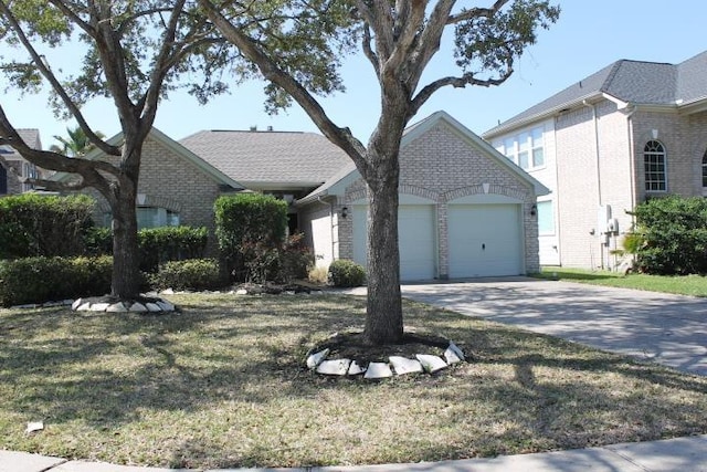 view of front facade featuring a garage, a front yard, brick siding, and driveway