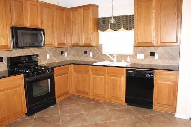 kitchen featuring black appliances, dark countertops, backsplash, and a sink