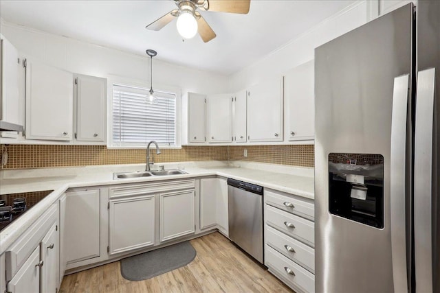 2342 Briarcliff Dr, Beaumont, TX 77706 - kitchen featuring stainless steel appliances, a sink, tasteful backsplash, a ceiling fan, and light wood-type flooring