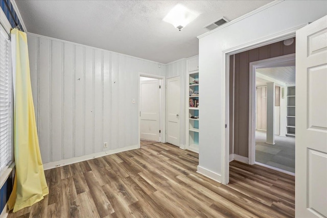 2342 Briarcliff Dr, Beaumont, TX 77706 - unfurnished bedroom featuring wood finished floors, baseboards, crown molding, and a textured ceiling