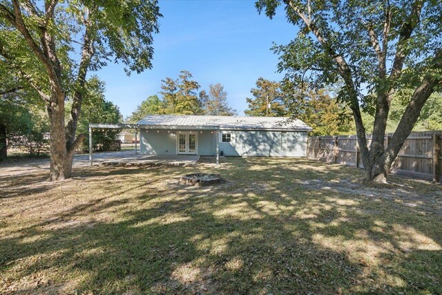 back of house featuring a yard and french doors