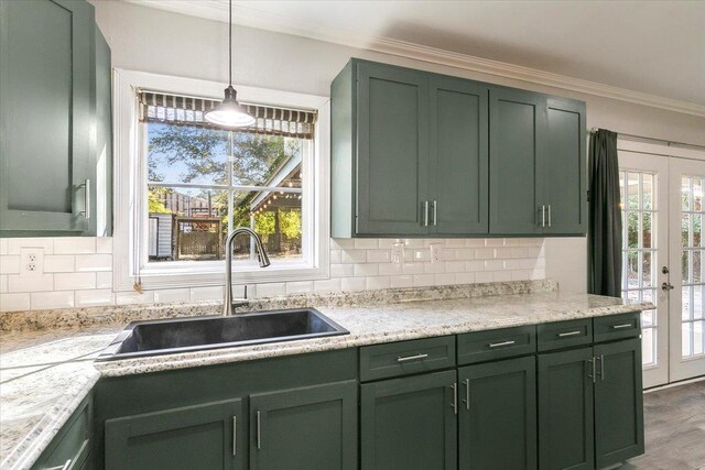 kitchen with decorative light fixtures, french doors, sink, and green cabinetry