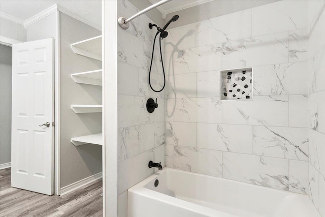 bathroom featuring wood-type flooring, tiled shower / bath, and crown molding