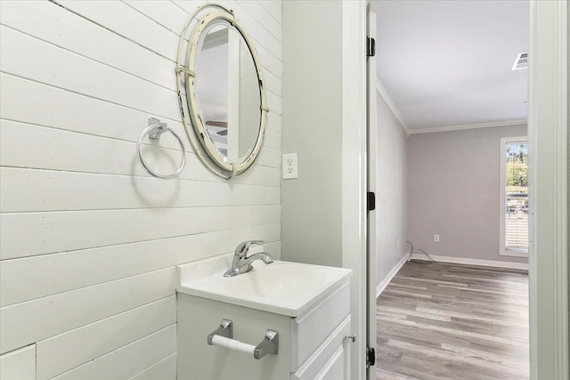 bathroom featuring crown molding, vanity, and hardwood / wood-style flooring