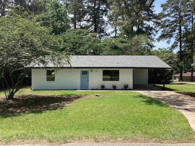 ranch-style home featuring brick siding, a shingled roof, concrete driveway, a front lawn, and a carport