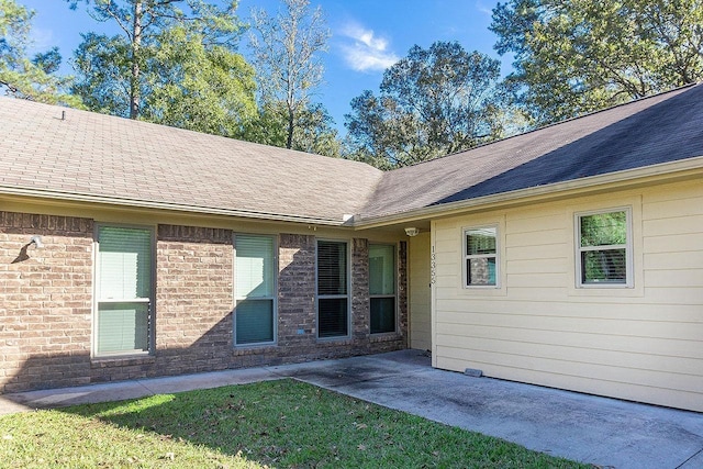 view of exterior entry featuring a lawn