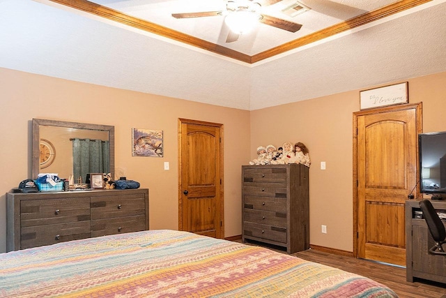 bedroom with vaulted ceiling, hardwood / wood-style flooring, ceiling fan, ornamental molding, and a textured ceiling