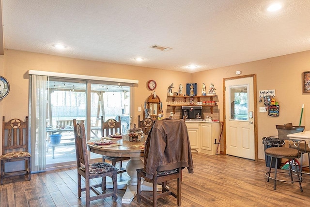 dining room featuring a textured ceiling and light hardwood / wood-style floors