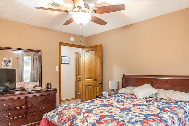 bedroom with ceiling fan and a textured ceiling