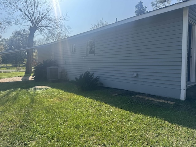 view of home's exterior featuring central AC unit and a yard