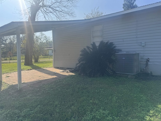 view of home's exterior featuring a lawn and central AC