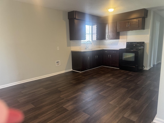 kitchen featuring tasteful backsplash, dark brown cabinetry, dark wood-type flooring, sink, and black / electric stove