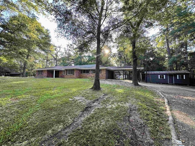 ranch-style home featuring a front lawn and a carport